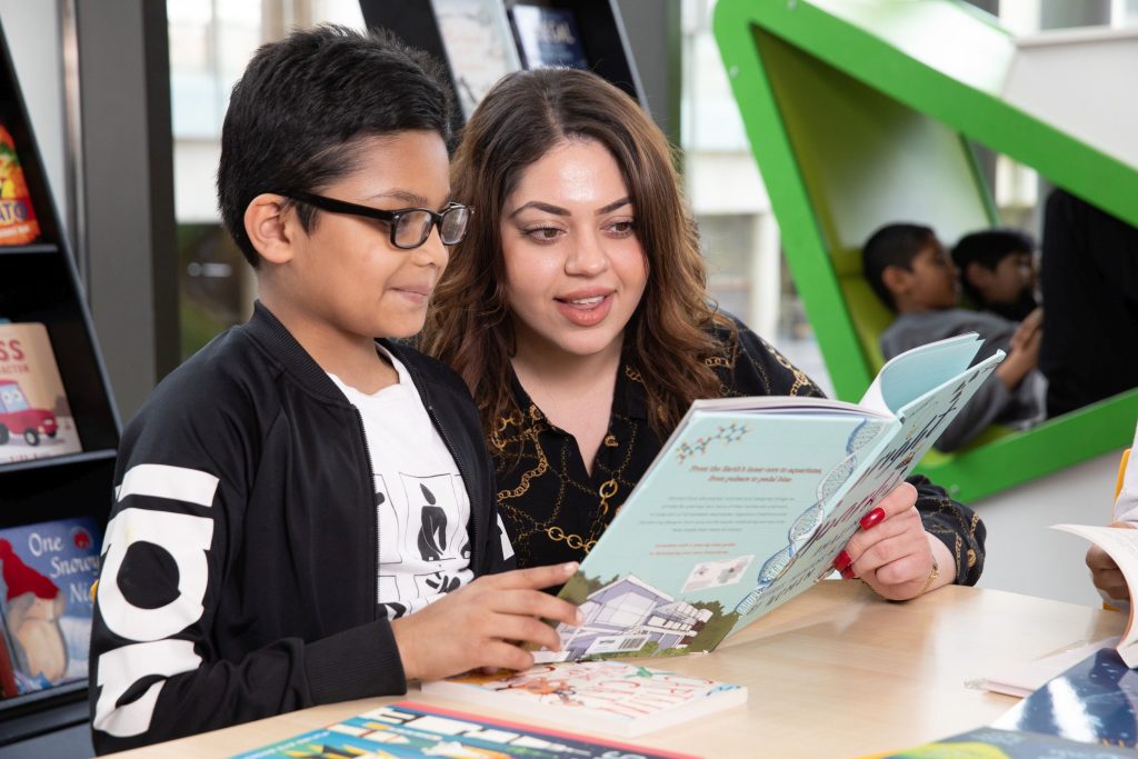 Mum and son reading together in their local library